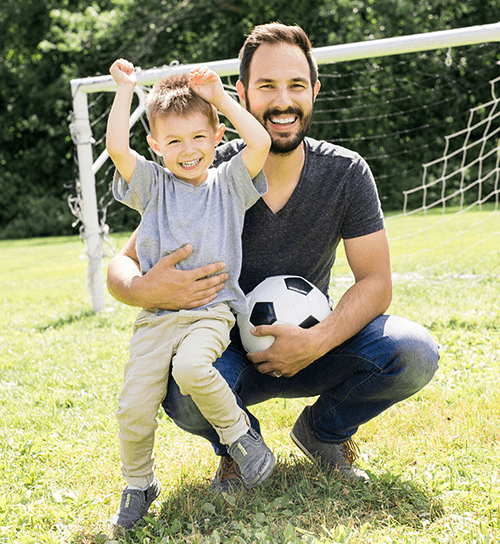 Man playing soccer with boy